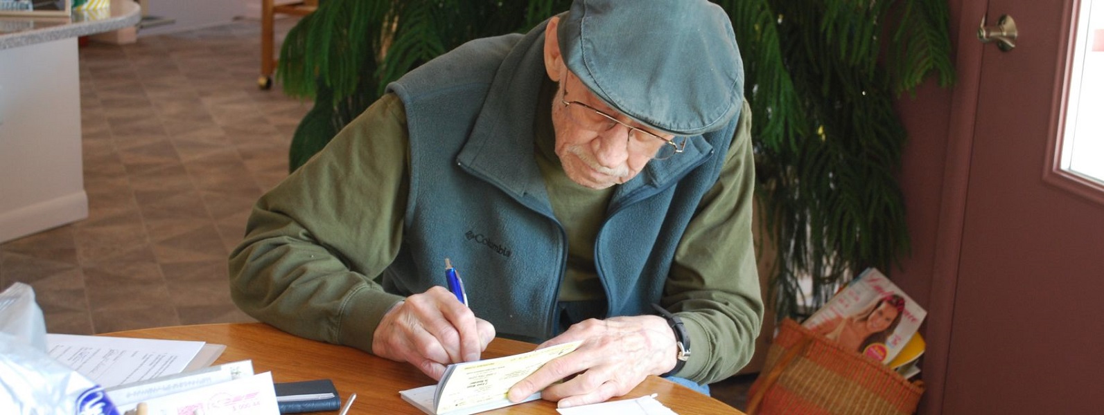 This is an image of Clayton Brockel, KPC's founding director, writing a check to provide for a donation to student scholarship endowments his family supported.