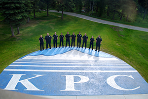 Police officers stand around image of college logo